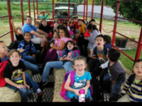 Fourteen happy kids on hay ride wagon