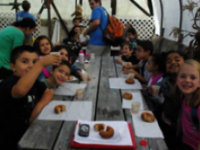 several kids creating crafts at outdoor table